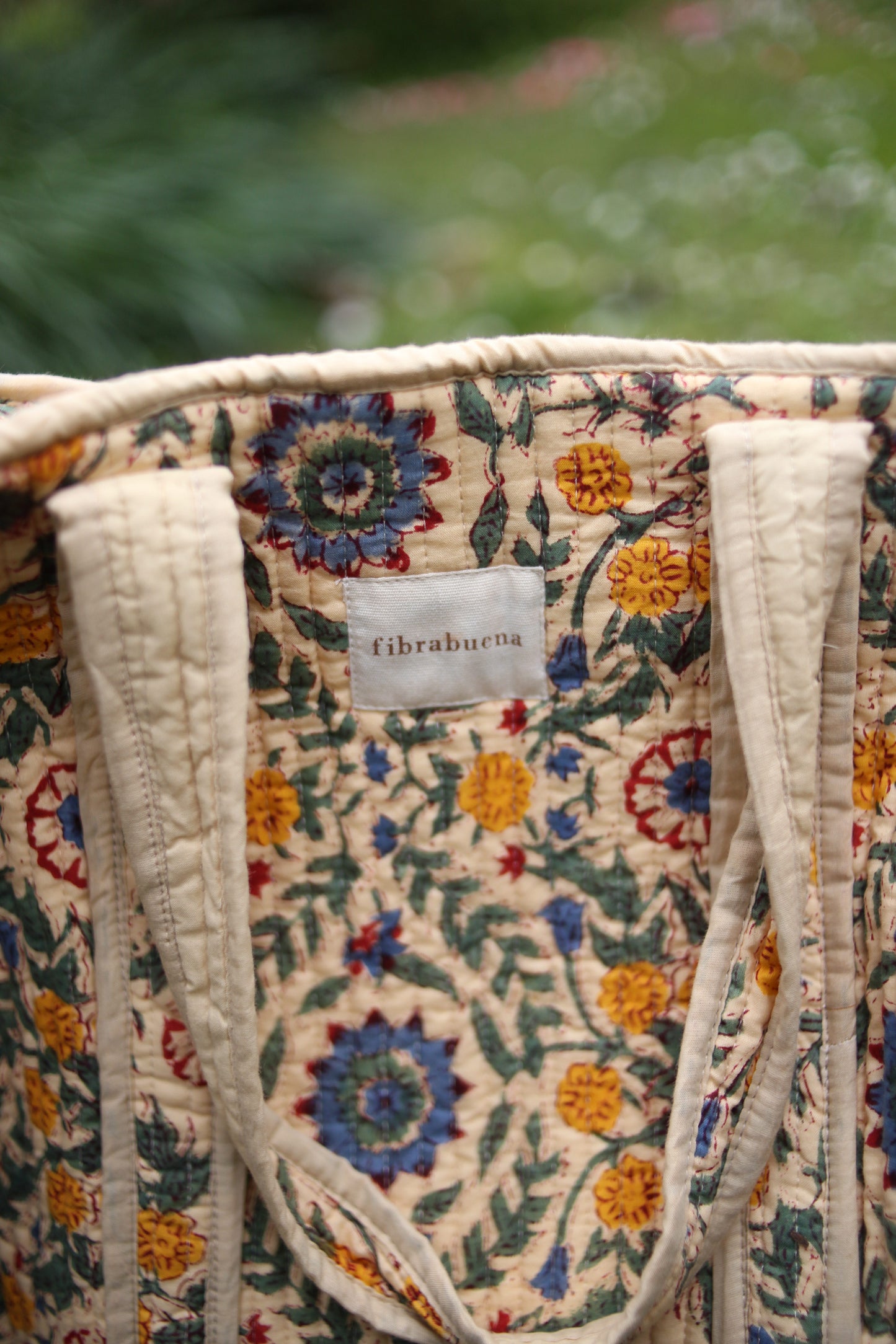 Bolso beige con motivos florales en amarillos, verdes y azules- zoom in