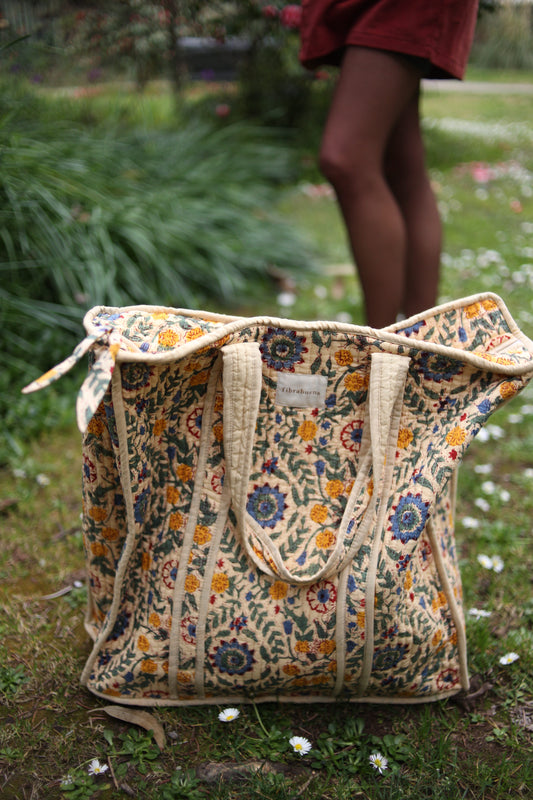 Bolso beige con motivos florales en amarillos, verdes y azules- vista frontal