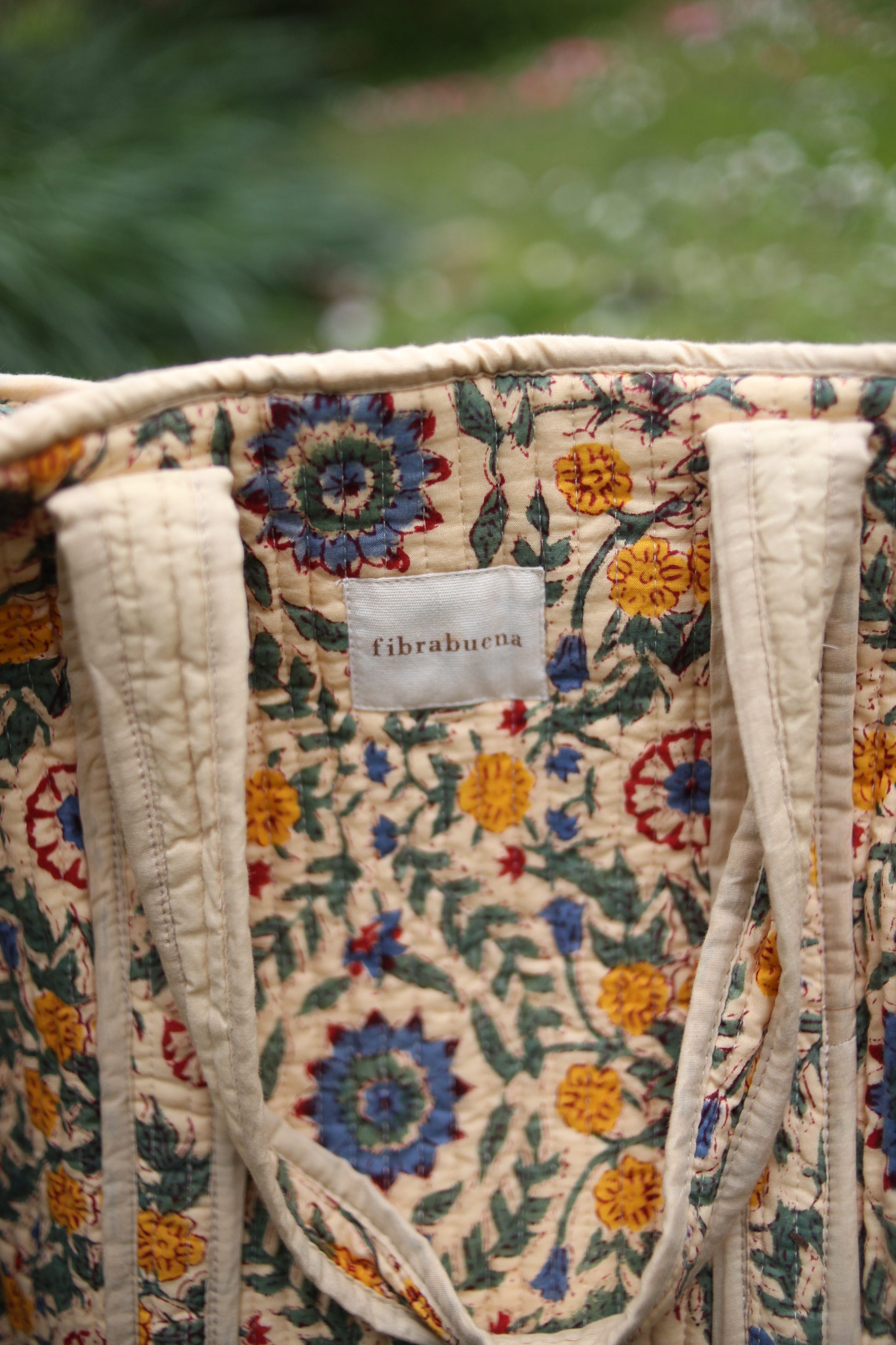 Bolso beige con motivos florales en amarillos, verdes y azules- zoom in