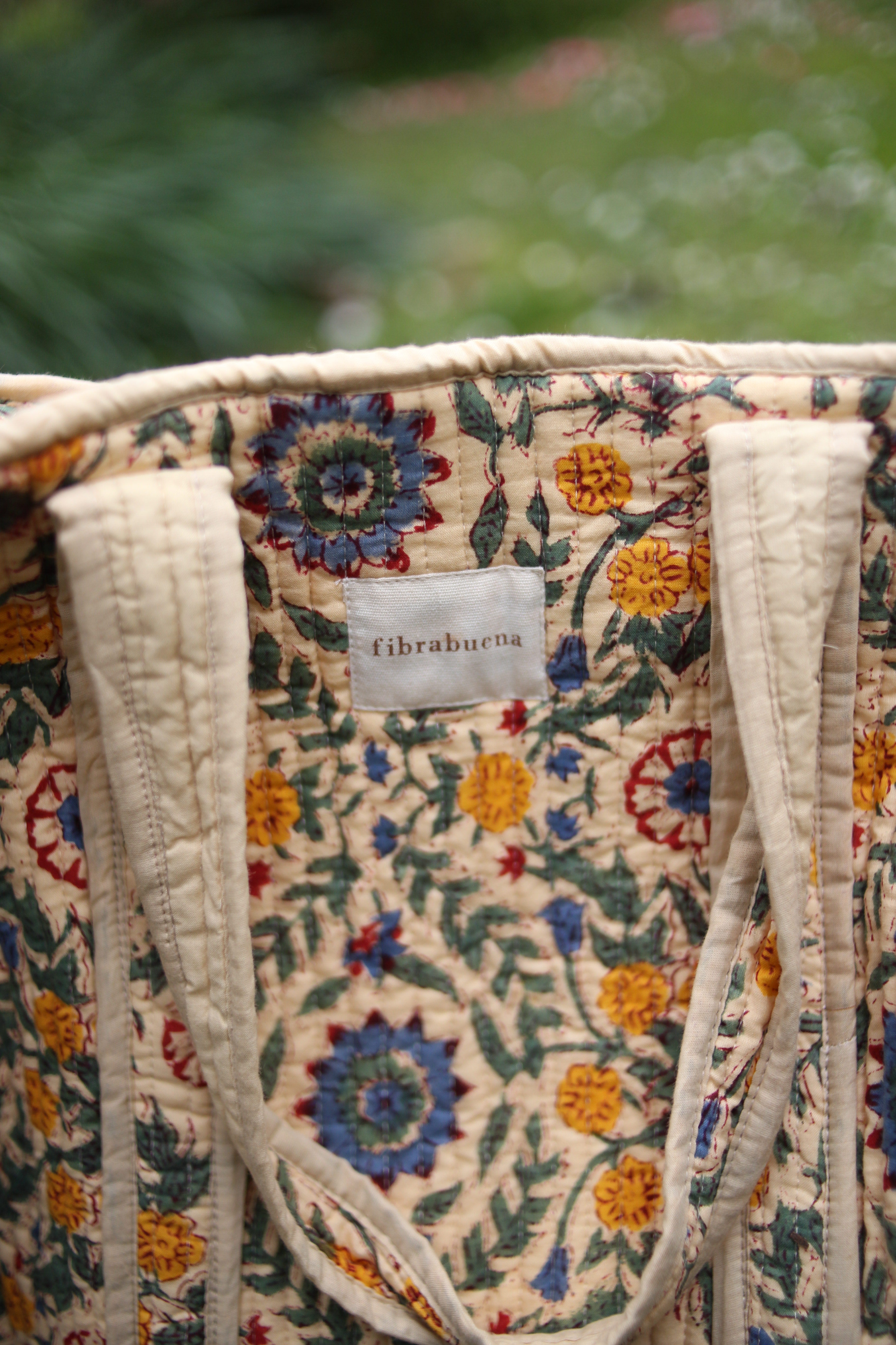 Bolso beige con motivos florales en amarillos, verdes y azules- zoom in