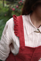 Jardinera cotelé burdeo - detalle tirante con vuelo y botón forrado