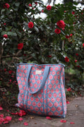 Bolso acolchado celeste con motivos florales en rosado - vista frontal