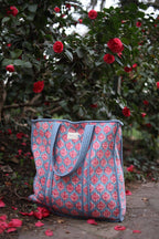 Bolso acolchado celeste con motivos florales en rosado - vista frontal